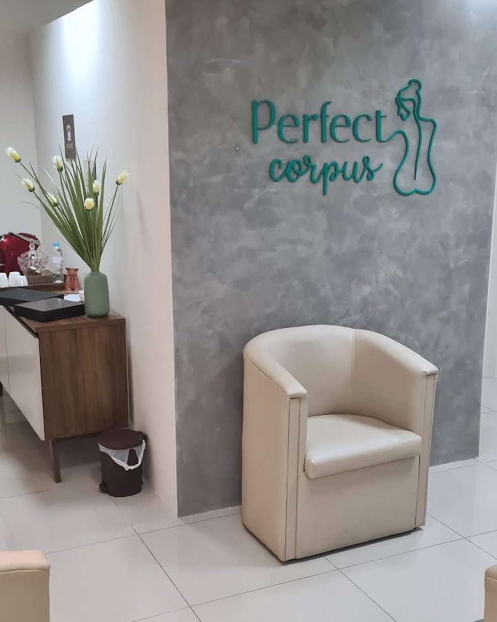 Recepção da Perfect Corpus: a logo na parede de cimento queimado e uma poltrona